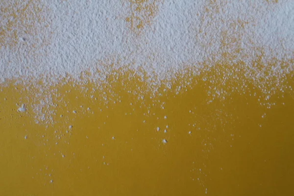 Yemek arkaplanı un pudrası şekeri sarı parlak bir zemin üzerine serpiştirilmiş ve metin fotoğrafı için bir telif yeri var..