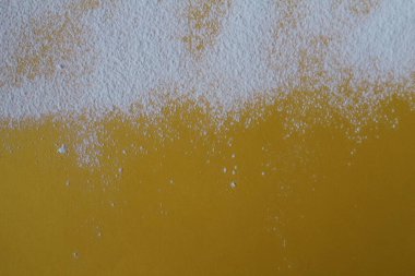 Yemek arkaplanı un pudrası şekeri sarı parlak bir zemin üzerine serpiştirilmiş ve metin fotoğrafı için bir telif yeri var..