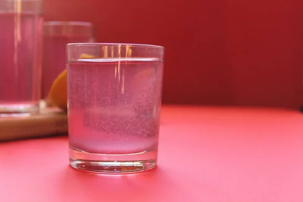 red drink of milky preparation of raspberry blueberries or kulbnik mors juice compote on a red background with a place for text and copyspace.