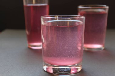 Kompote suyu süt tırnağını pembeleştirir siyah gri bir zemin üzerinde metin ve kopyalanma alanı ile.