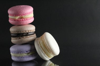 Makarna lavantalı beyaz çikolatalı kekler kaydırak şeklinde ve biri siyah arka planda Fransız mutfağında yemek pişirme tatlısı mesaj atılacak bir yerde..