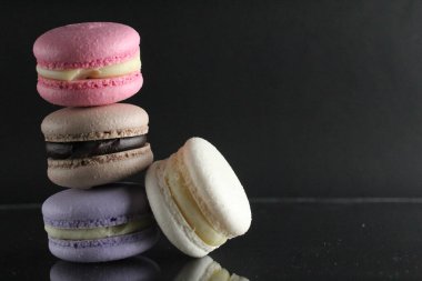 Makarna lavantalı beyaz çikolatalı kekler kaydırak şeklinde ve biri siyah arka planda Fransız mutfağında yemek pişirme tatlısı mesaj atılacak bir yerde..