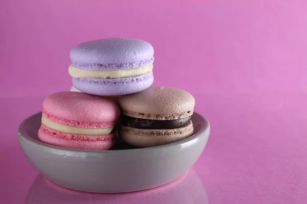 Macaroons Três Multicolorido Uma Placa Disco Cinza Fica Fundo Rosa — Fotografia de Stock