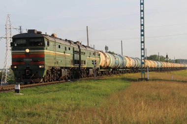 Gökyüzüne karşı çim çayırlarının arasında kargo gezintisi yapıyorlardı. Demiryolu taşımacılığı. Aktarım.