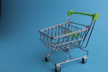 Telif alanı olan mavi arka planda bir alışveriş arabası. Satın alma. İş. Alıcı talebi. Dükkan. Alıcılar.