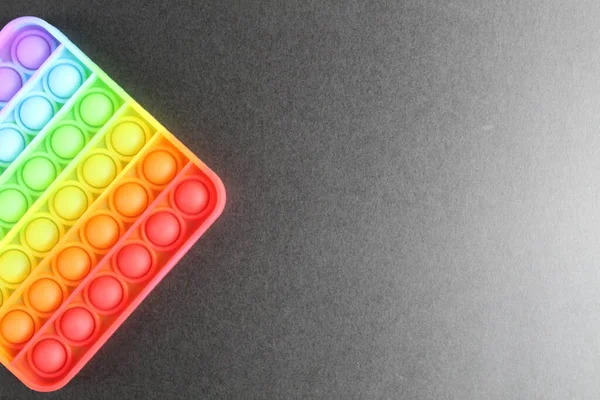 Strese karşı oyuncak popit simlpe gamzeli gökkuşağı üstten siyah arkaplan görünümü ve metin kopyalanması için boşluk.