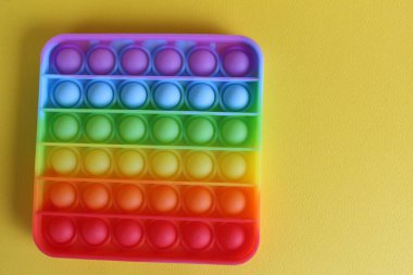 Stres önleyici oyuncak, yukarıdan basit gamzeli görünüm, sarı bir arkaplan, metin için bir yer ve kopyalanacak bir alan..