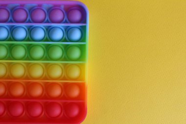 Stres önleyici oyuncak, yukarıdan basit gamzeli görünüm, sarı bir arkaplan, metin için bir yer ve kopyalanacak bir alan..