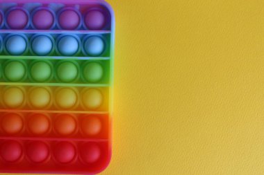 Stres önleyici oyuncak, yukarıdan basit gamzeli görünüm, sarı bir arkaplan, metin için bir yer ve kopyalanacak bir alan..