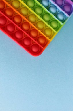 Stres önleyici oyuncak popit mavi arka planda basit bir gamze, mesaj atılacak bir yer ve kopyasıyla. Yukarıdan görüntüle.