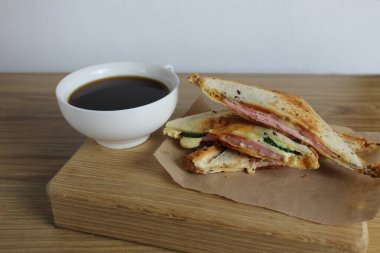 Sandviç tepsisinde kahvaltı. Yanında da ahşap tepside salam peyniri ve çay. Odaya kahvaltı var. Sabah kahvesi.