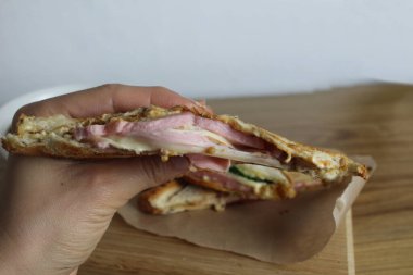 Kız peynirli sandviçi elleriyle kırıyor. Kahvaltı. İşlenmiş peynir.