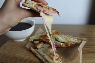 Kız peynirli sandviçi elleriyle kırıyor. Kahvaltı. İşlenmiş peynir.