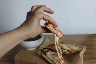 Kız peynirli sandviçi elleriyle kırıyor. Kahvaltı. İşlenmiş peynir.