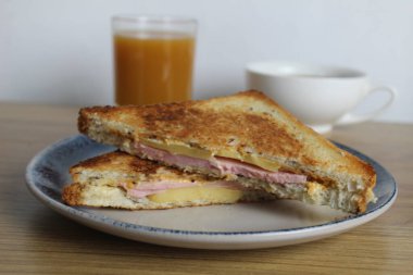 Yemek, avtrak. Jambonlu ve sebzeli sandviçler masada portakallı kayısı suyunun yanında gri bir tabakta yatar. Kahvaltı hazırlıyorum..