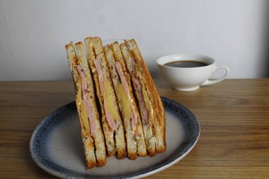 Yemek, avtrak. Jambonlu ve sebzeli sandviçler masada portakallı kayısı suyunun yanında gri bir tabakta yatar. Kahvaltı hazırlıyorum..