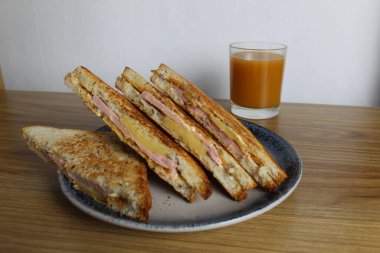 Yemek, avtrak. Jambonlu ve sebzeli sandviçler masada portakallı kayısı suyunun yanında gri bir tabakta yatar. Kahvaltı hazırlıyorum..