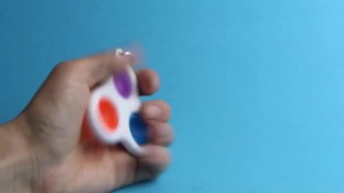 Kamera oyuncak anti-sressing popit yaklaşır basit bir gamze aşağı ahşap bir standın vasiyeti mavi bir arka planda.