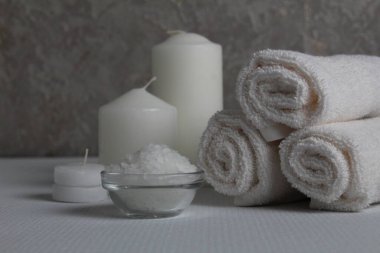 Spa salonu, spa tedavileri. Havlular, mumlar beyaz bir arkaplana sarmak için tuz ve metin için bir yer ve bir telif alanı ile.