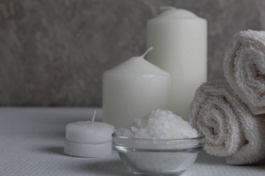 Spa salonu, spa tedavileri. Havlular, mumlar beyaz bir arkaplana sarmak için tuz ve metin için bir yer ve bir telif alanı ile.