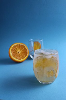 Adım adım limonata yapmak için. Adım 2. Meyve portakalını soda ile doldur. Mavi arka planda bir bardak portakallı limonata ve mesaj için bir yer. yakın plan.