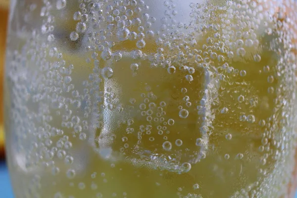 氷とオレンジのガラスの中でのレモネード水の離婚は非常に近いです マクロ写真 — ストック写真
