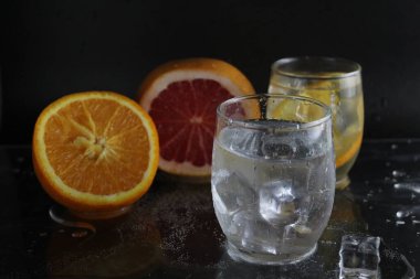 Buz küpü sinekleri, siyah zemin üzerinde portakal greyfurt ve buz yatarken yanında soda ile takanın içine düşer. İçkileri tazeliyorum. Limonata, meyve suyu..