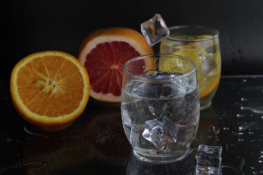 Buz küpü sinekleri, siyah zemin üzerinde portakal greyfurt ve buz yatarken yanında soda ile takanın içine düşer. İçkileri tazeliyorum. Limonata, meyve suyu..