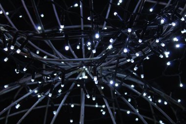 Koyu siyah arka planda mavi çelenkler. Yılbaşı arifesi geçmişi. Neşeli ışıklandırma.