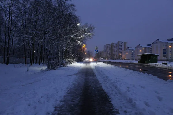 在冬城的夜景中 在雪地里靠近小巷的树木点亮了房屋和灯笼 — 图库照片