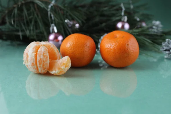 Mandarins Three Lie Next Christmas Tree Green Background Festive Atmosphere — Stock Photo, Image