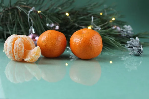 Mandarins Three Lie Next Christmas Tree Green Background Festive Atmosphere — Stock Photo, Image