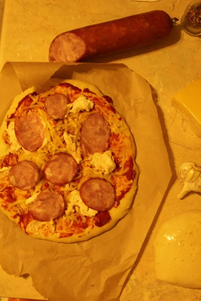 Pizza Kiełbasą Szynki Domowe Posiłki Pizzy Leżą Pergaminie Obok Kiełbasy — Zdjęcie stockowe