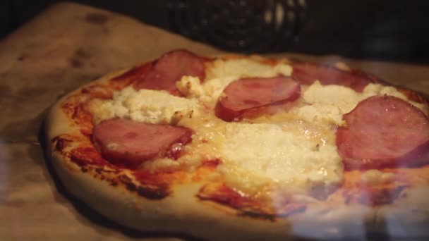 ピザだ ピザはオーブンで焼かれます 空気を吹いて紙を動かし チーズを溶かす 自家製食品 — ストック動画