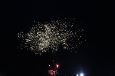 Havai fişeklerin başlangıcı karanlık gökyüzünde ışık saçar. Havai fişeklerin ilk gülleri.