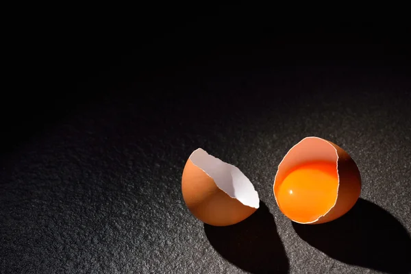 Primer plano del huevo agrietado sobre fondo de mesa negro — Foto de Stock