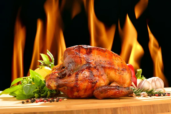 Roasted chicken and various vegetables on a chopping wood