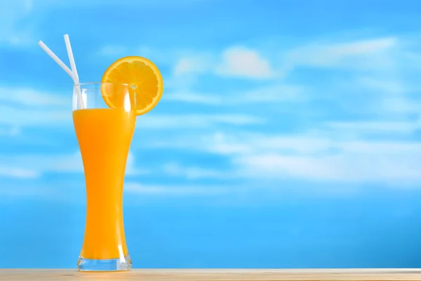Orange juice and slices of orange on sky background — Stock Photo, Image