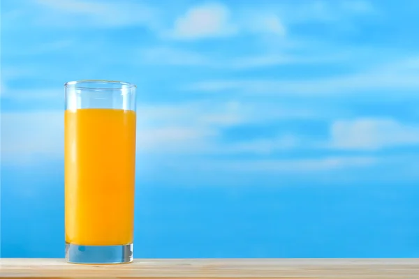 Sok pomarańczowy z szkła na tle nieba — Zdjęcie stockowe