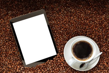 Boş beyaz ekran ve kahve kahve çekirdekleri yığını üzerinde olan tablet bilgisayar