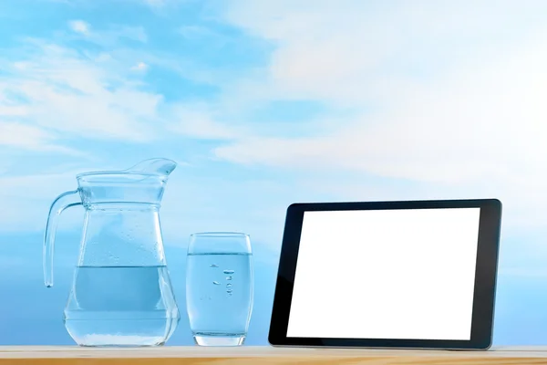 Планшетный компьютер и чистая питьевая вода — стоковое фото