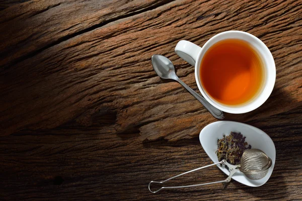 Vista superior da xícara de chá com folhas de chá na mesa de madeira — Fotografia de Stock