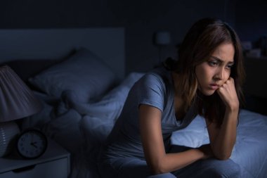 Depresyonda olan genç Asyalı kadın uykusuzluktan uyuyamıyor.