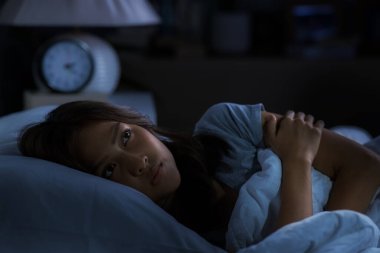 Depresyonda olan genç bir kadın uykusuzluktan uyuyamaz.