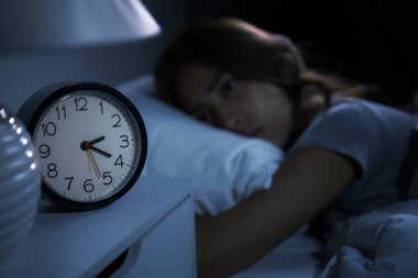 Depresyonda olan genç bir kadın uykusuzluktan uyuyamaz. Alarm saatine seçmeli odaklan
