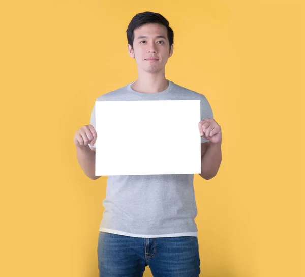 Ásia Homem Segurando Branco Cartaz Isolado Amarelo Fundo — Fotografia de Stock