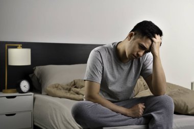Depresyonda olan Asyalı genç adam uykusuzluktan uyuyamıyor.