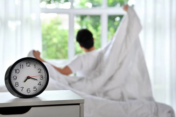 Uomo Svegliarsi Mattina Seduto Sul Letto Stretching Concentrarsi Sulla Sveglia — Foto Stock