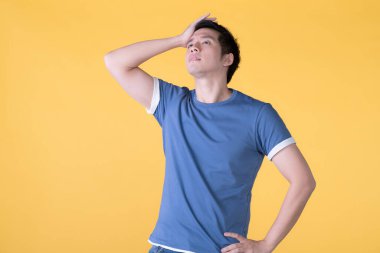 Asyalı adam sıkıldı, sarı arka planda izole edildi.