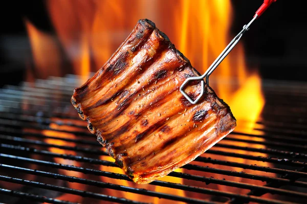 Grillowane żeberka wieprzowe na płonącym grillu — Zdjęcie stockowe